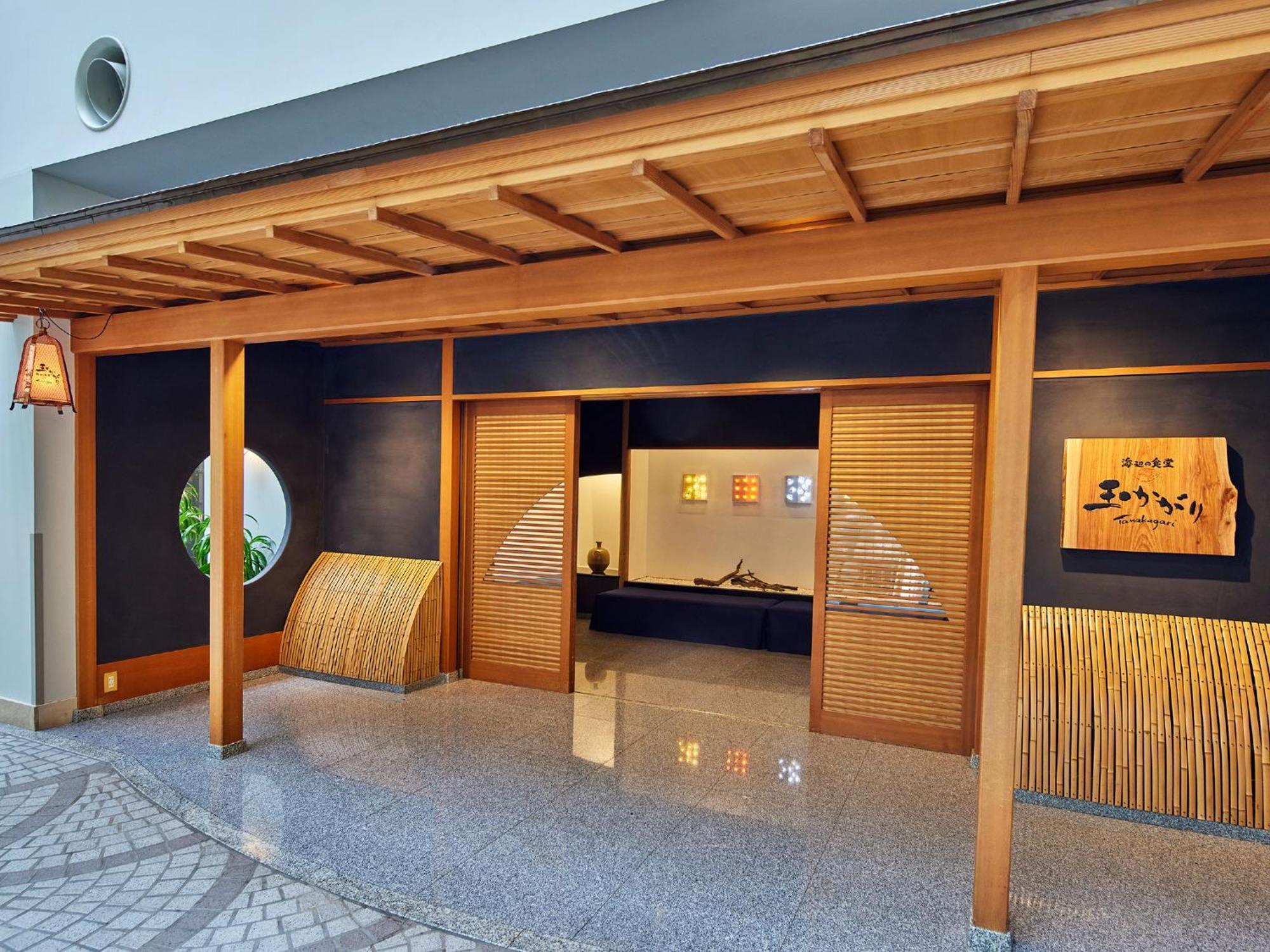 فندق Grand Nikko Tokyo Bay Maihama Urayasu المظهر الخارجي الصورة The photo shows the entrance of a building, designed in a traditional Japanese style. It features a wooden structure with a large overhanging roof and sliding doors. The entrance is flanked by rounded windows, and there's a decorative sign with Japan