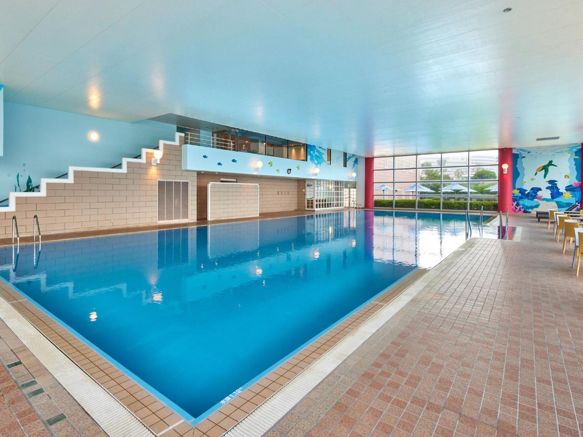 فندق Grand Nikko Tokyo Bay Maihama Urayasu المظهر الخارجي الصورة The photo shows an indoor swimming pool area with a spacious design. The pool has a clear blue water surface and is surrounded by a tiled deck. On one side of the pool, there are steps leading into the water, and there are large windows letting in na